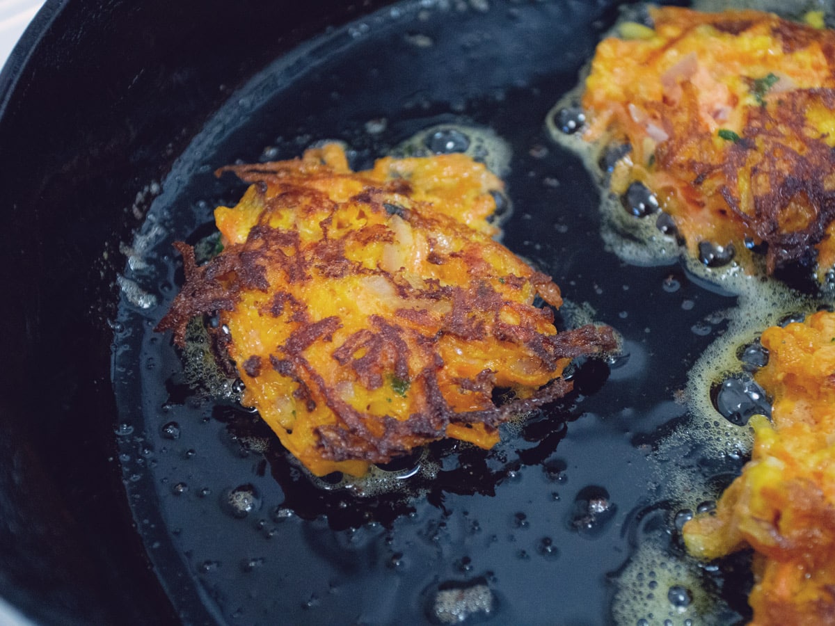 carrot fritters cooking in skillet