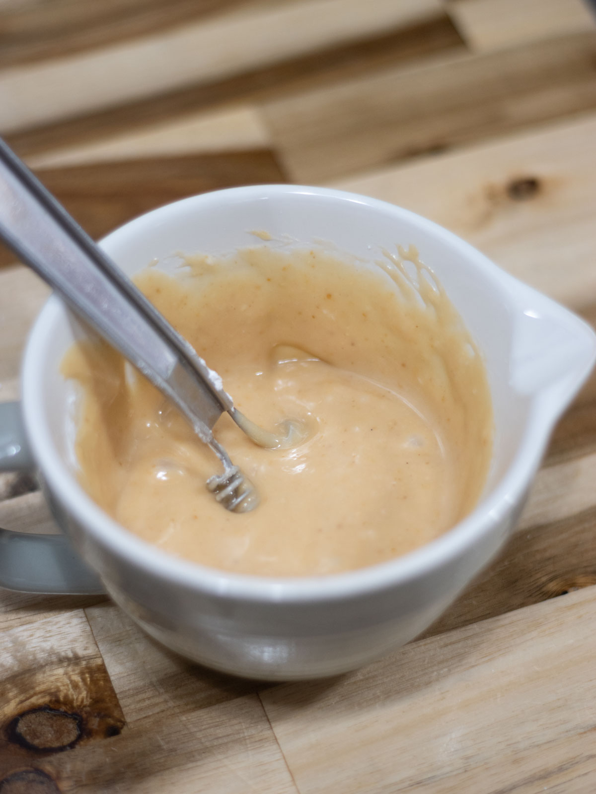 peanut butter glaze and a whisk in a small bowl