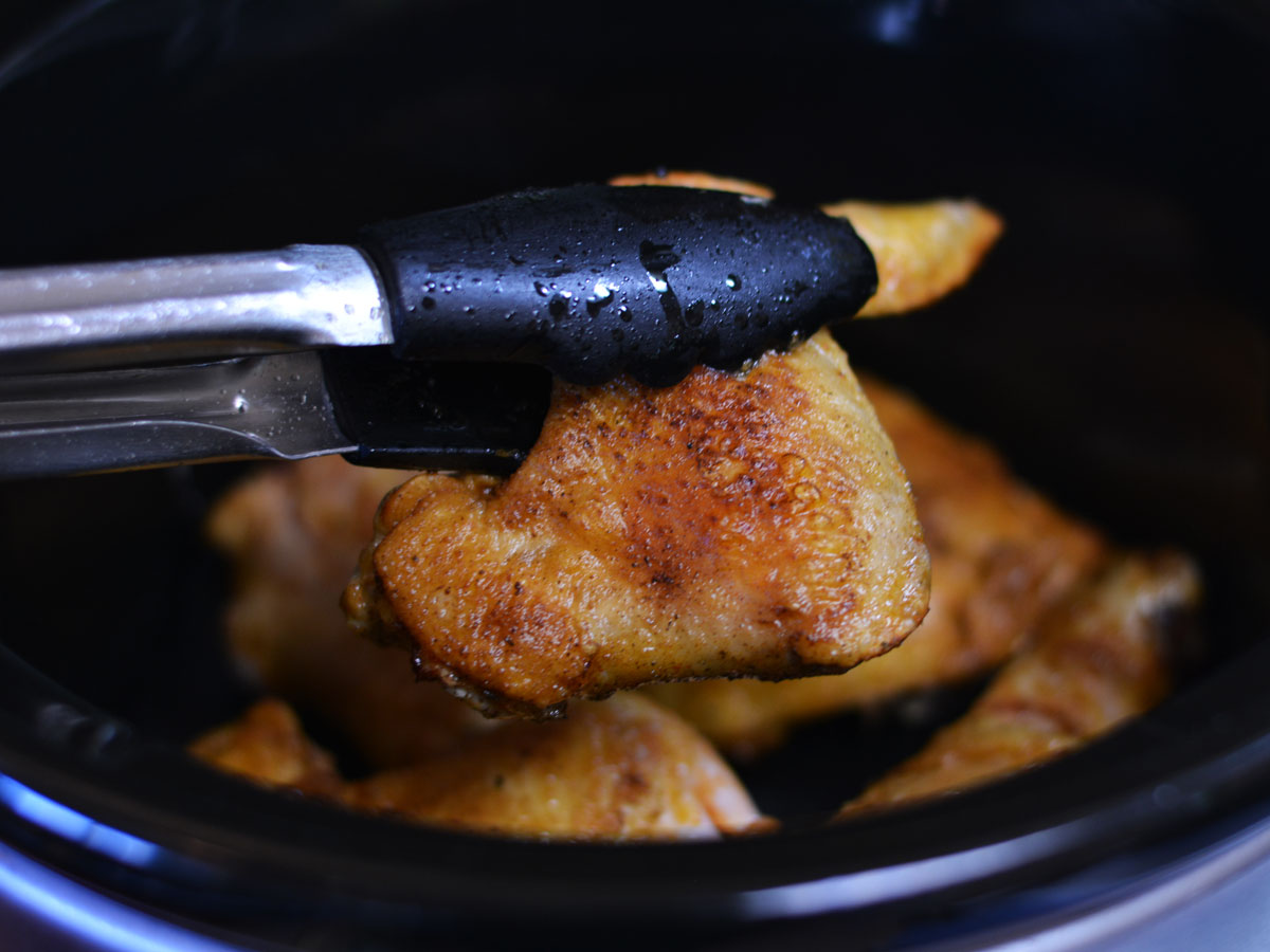 chicken pieces going into a slow cooker