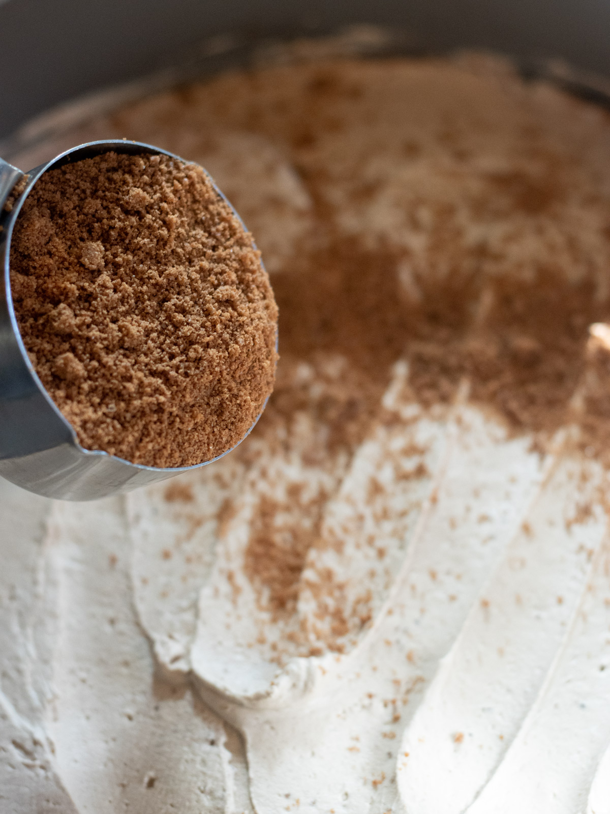 sprinkling cookie crumbs over icebox cake filling